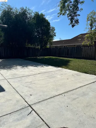 a view of backyard and wooden fence