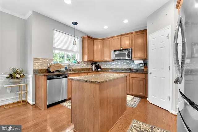 a kitchen with stainless steel appliances granite countertop a stove a sink and a refrigerator