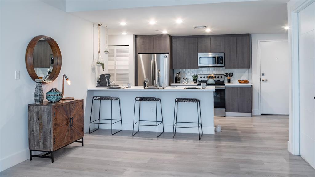 425-475 East Atlantic Boulevard, Unit 410 Pompano Beach, FL 33060 - Photo 18 of 40 a kitchen with stainless steel appliances granite countertop a stove a sink and a refrigerator