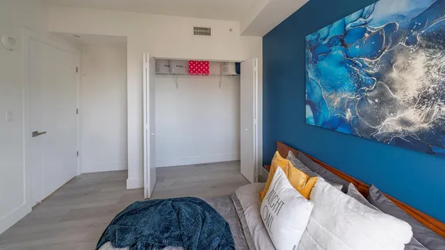 a bedroom with a bed and a painting on the wall