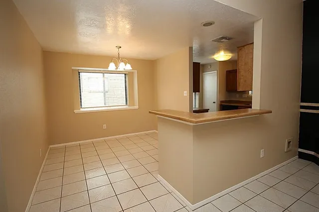 a view of an empty room with window and cabinet