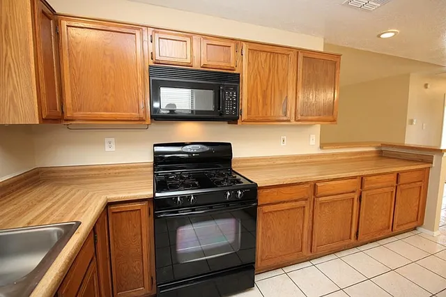 a kitchen with granite countertop cabinets stainless steel appliances and a counter space