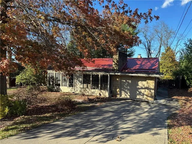 a front view of a house with a tree