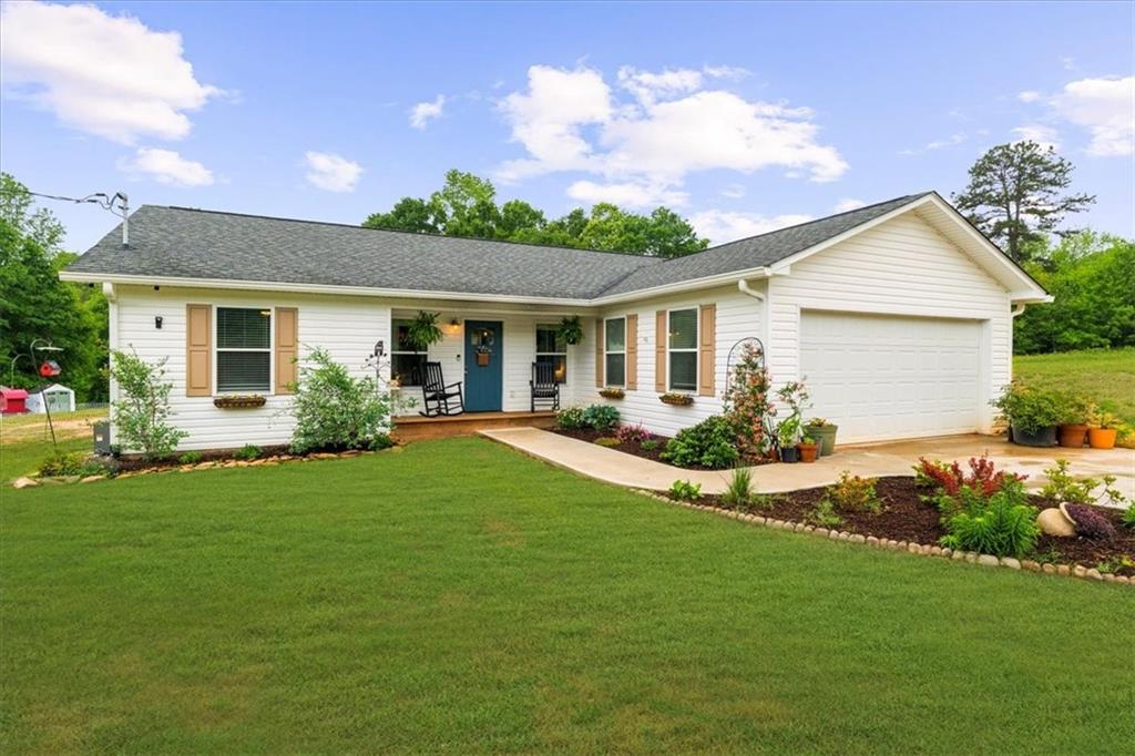 a front view of a house with a garden and plants