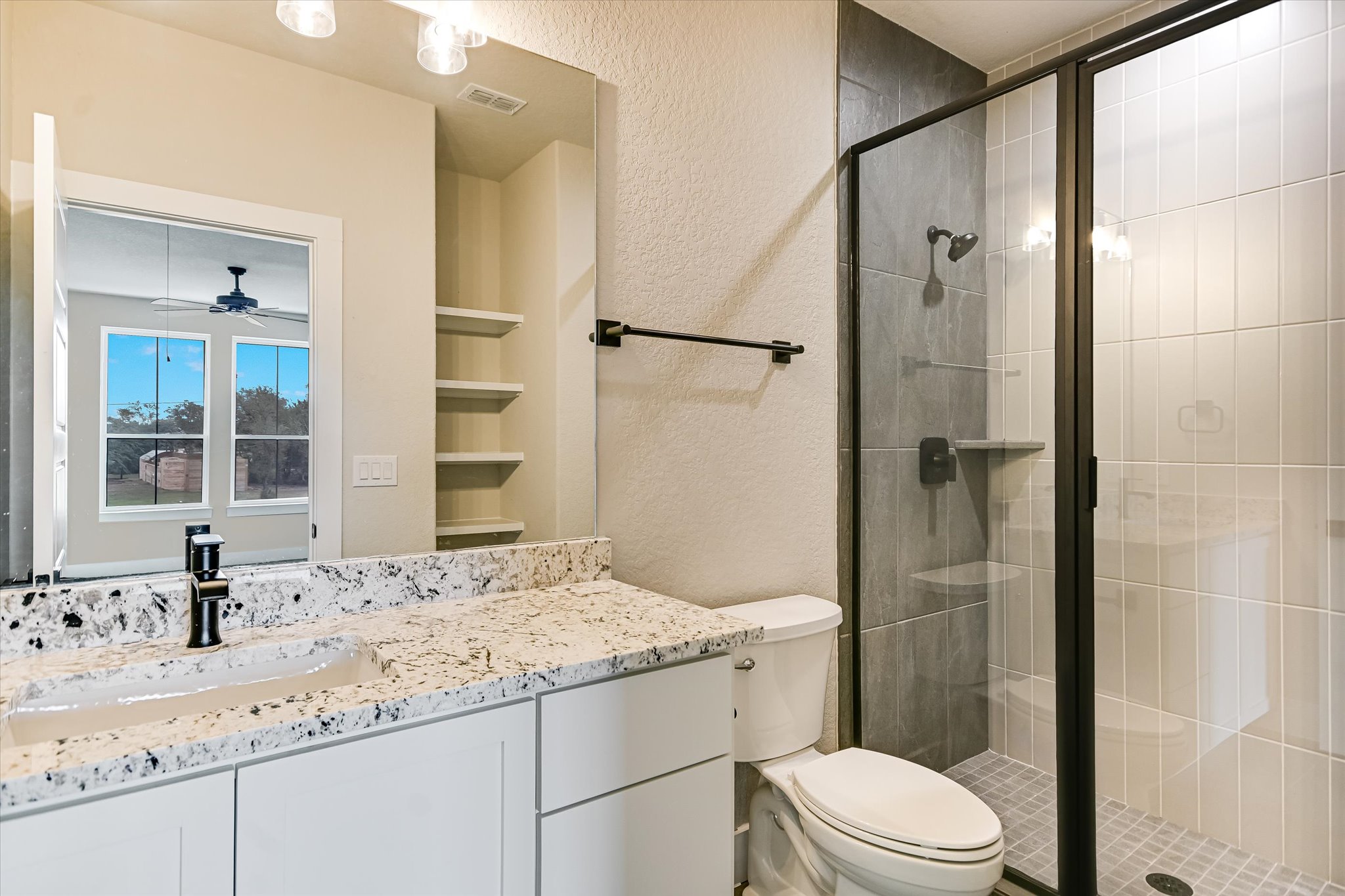 31 Peace Pipe Wimberley, TX 78676 - Photo 10 of 20 Full bath featuring a textured wall, a stall shower, vanity, and a ceiling fan