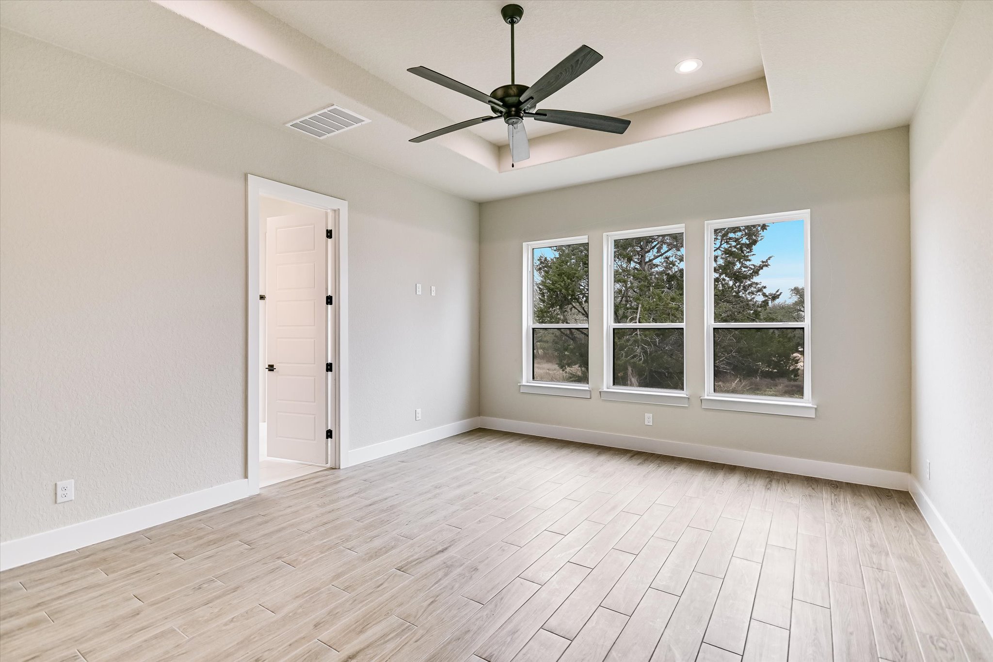 31 Peace Pipe Wimberley, TX 78676 - Photo 11 of 20 Spare room with wood finish floors, ceiling fan, and a raised ceiling