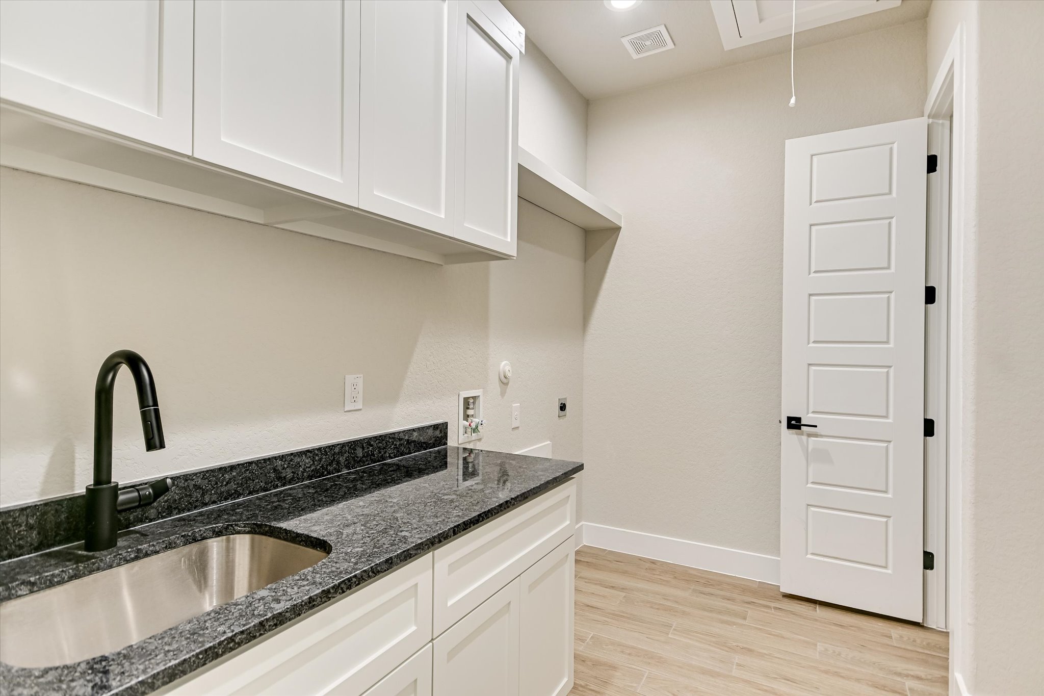 31 Peace Pipe Wimberley, TX 78676 - Photo 7 of 20 Laundry room with cabinet space, light wood finished floors, hookup for an electric dryer, and hookup for a washing machine