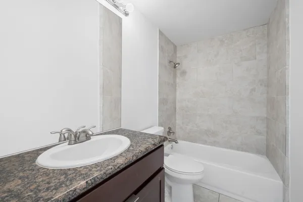 a bathroom with a granite countertop sink toilet and a mirror