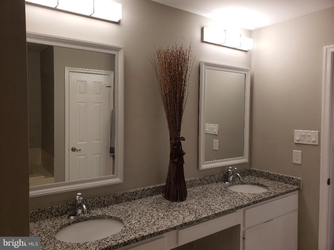 8049 Rising Ridge Road Bethesda, MD 20817 - Photo 20 of 33 a bathroom with a granite countertop sink and a mirror