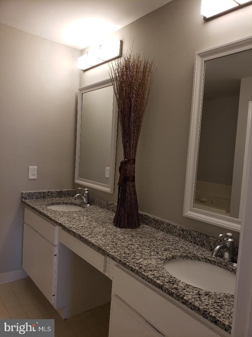 8049 Rising Ridge Road Bethesda, MD 20817 - Photo 21 of 33 a bathroom with a granite countertop sink and a mirror