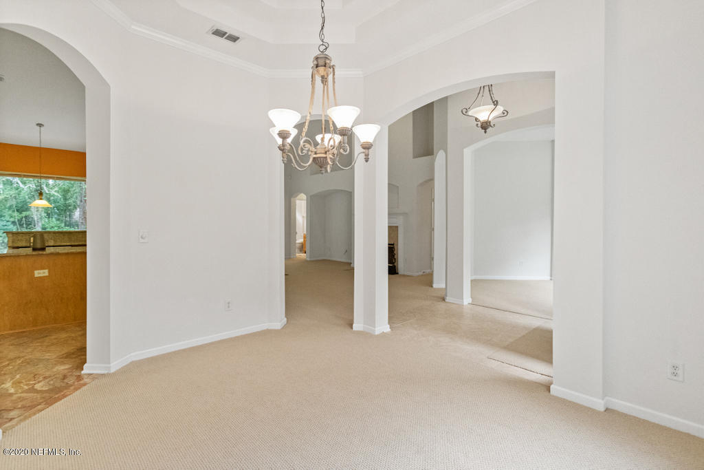 2576 Benjamin Road Jacksonville, FL 32223 - Photo 11 of 53 en empty room with chandelier fan and kitchen view