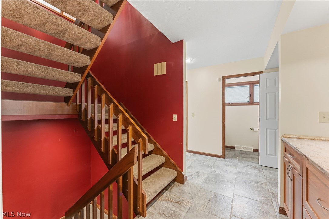 5741 Som Center Road, Unit 1 Solon, OH 44139 - Photo 6 of 50 Carpeted staircase with wood railing and red accent wall