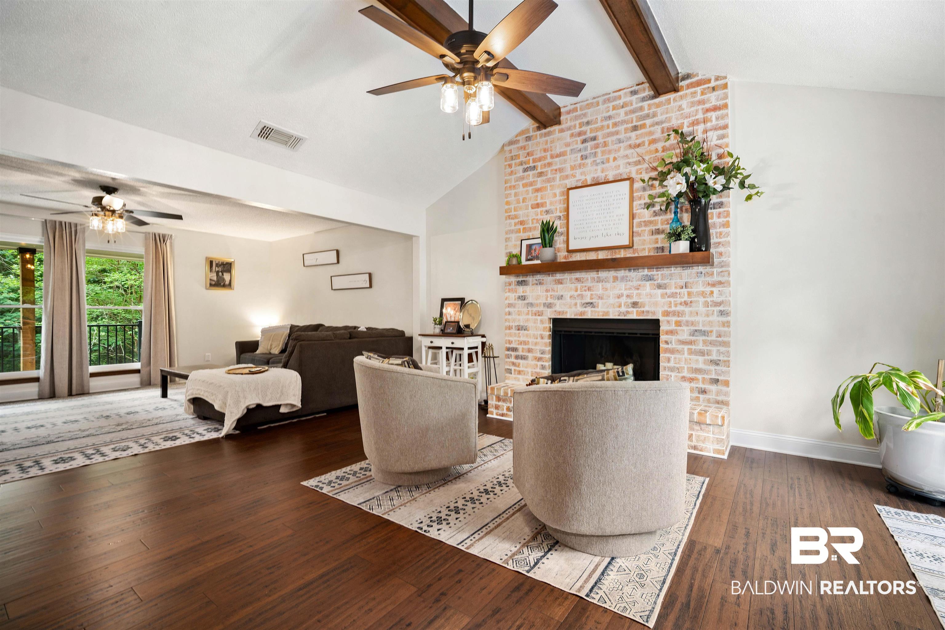 71 Caisson Trace Daphne, AL 36527 - Photo 15 of 36 Living area featuring a brick fireplace with a wood mantel, vaulted ceilings with wood beams, and a ceiling fan