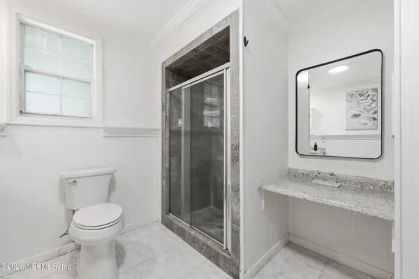 an aerial view of residential houses with outdoor space and trees