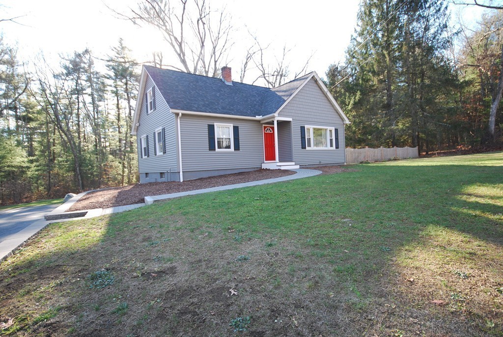 a front view of a house with a yard and trees