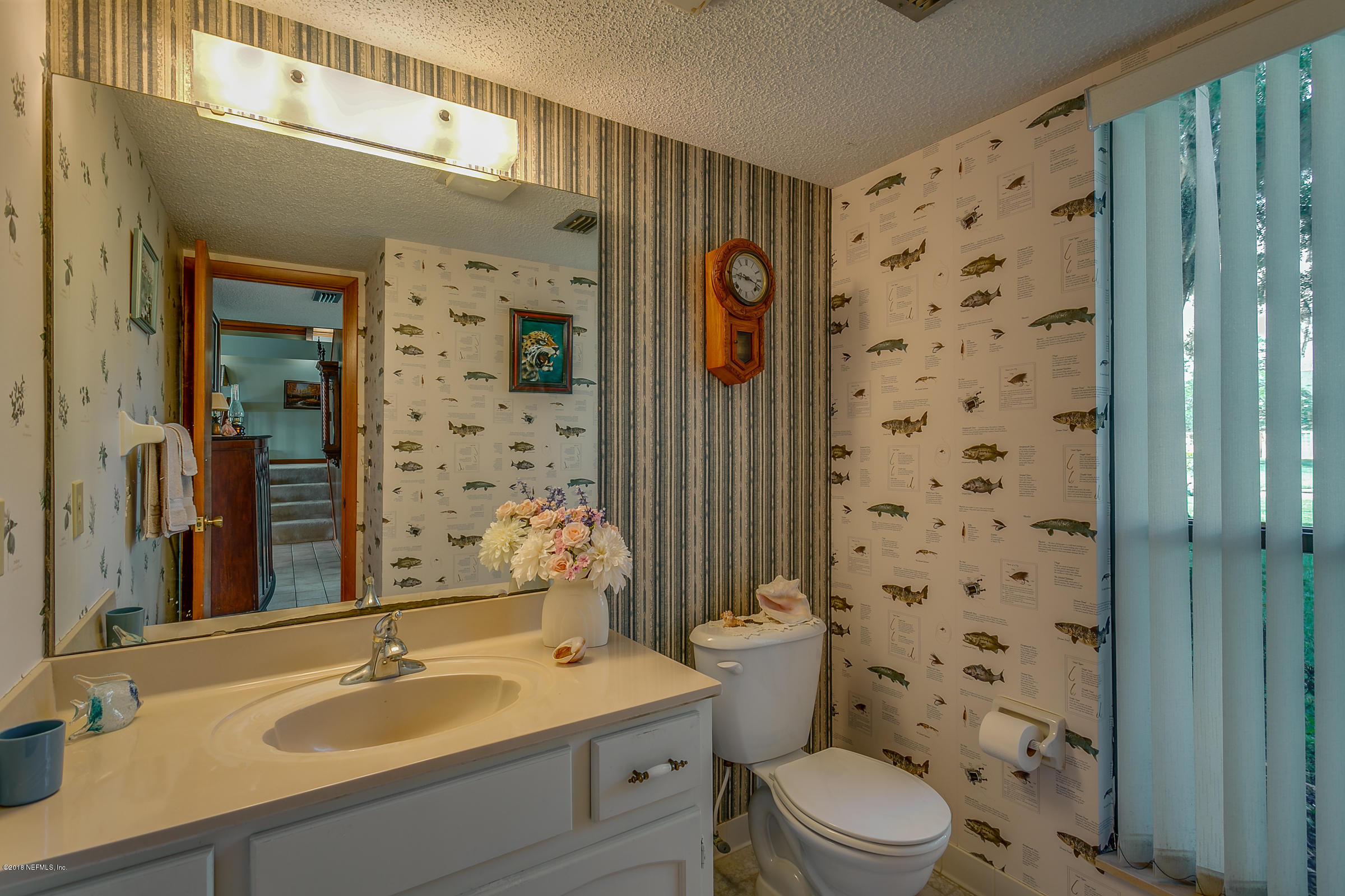 5562 Steamboat Road St. Augustine, FL 32092 - Photo 12 of 49 a bathroom with a sink a toilet a glass door shower and a mirror