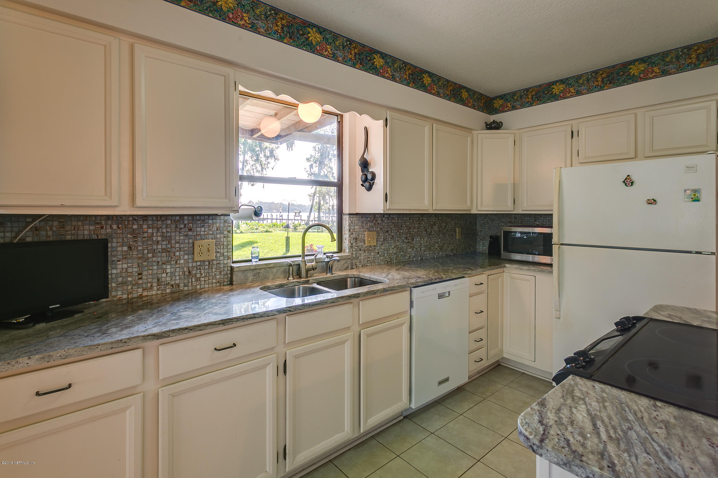 5562 Steamboat Road St. Augustine, FL 32092 - Photo 8 of 49 a kitchen with granite countertop white cabinets white appliances a sink and a window