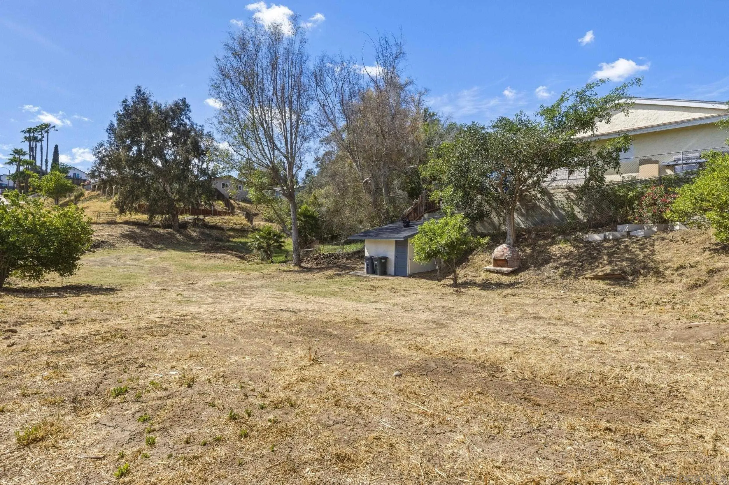 1862 Washington Street Lemon Grove, CA 91945 - Photo 27 of 32 a backyard of a house with large trees and outdoor space