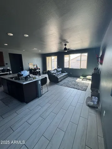 a living room with stainless steel appliances furniture a rug a fireplace and a window