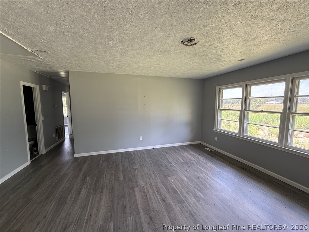 736 Tobermory Road Fayetteville, NC 28306 - Photo 6 of 17 an empty room with wooden floor and windows