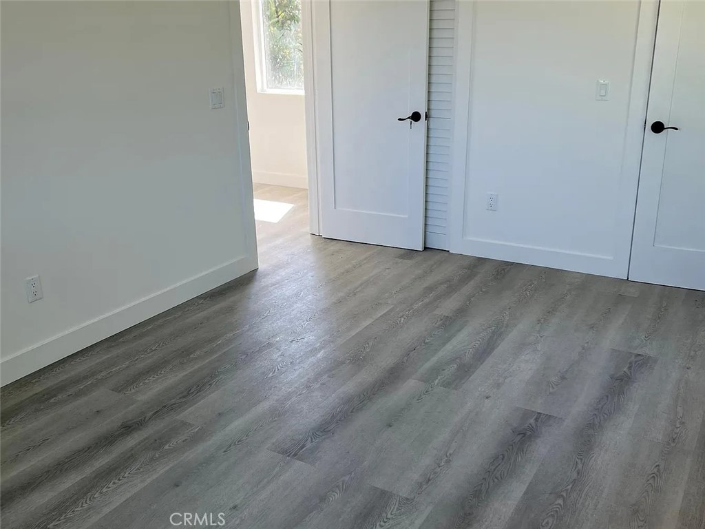 22823 Crespi Street Woodland Hills, CA 91364 - Photo 13 of 15 a view of an empty room with wooden floor and a window
