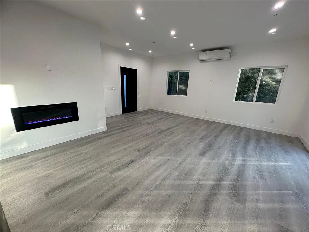 22823 Crespi Street Woodland Hills, CA 91364 - Photo 3 of 15 an empty room with wooden floor and windows