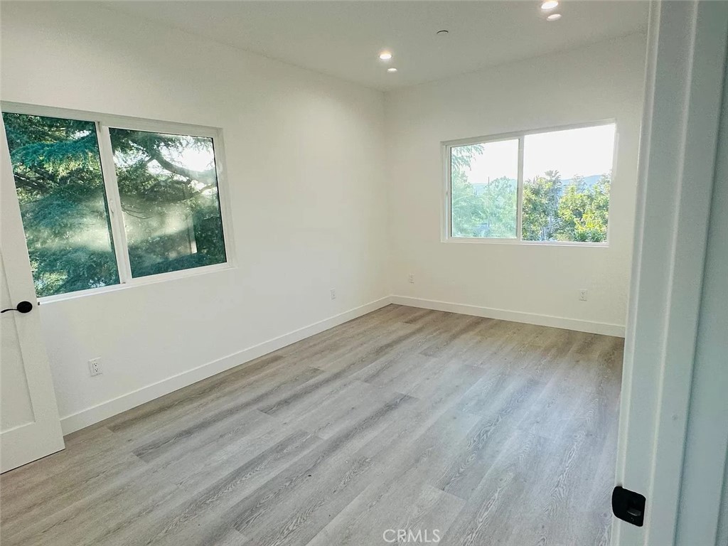 22823 Crespi Street Woodland Hills, CA 91364 - Photo 8 of 15 an empty room with wooden floor and windows