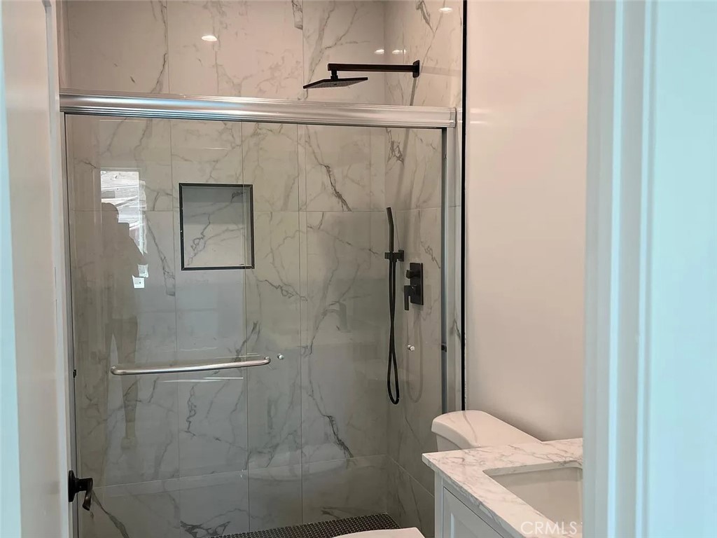 22823 Crespi Street Woodland Hills, CA 91364 - Photo 9 of 15 a bathroom with a granite countertop shower and a toilet