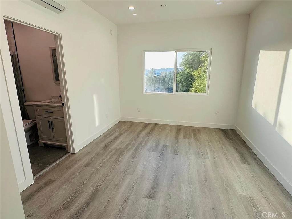 22823 Crespi Street Woodland Hills, CA 91364 - Photo 10 of 15 an empty room with wooden floor and a window