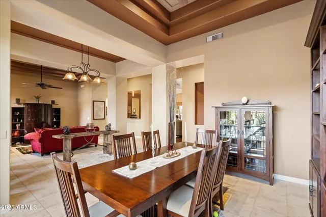 a kitchen with stainless steel appliances kitchen island granite countertop a table chairs and a refrigerator