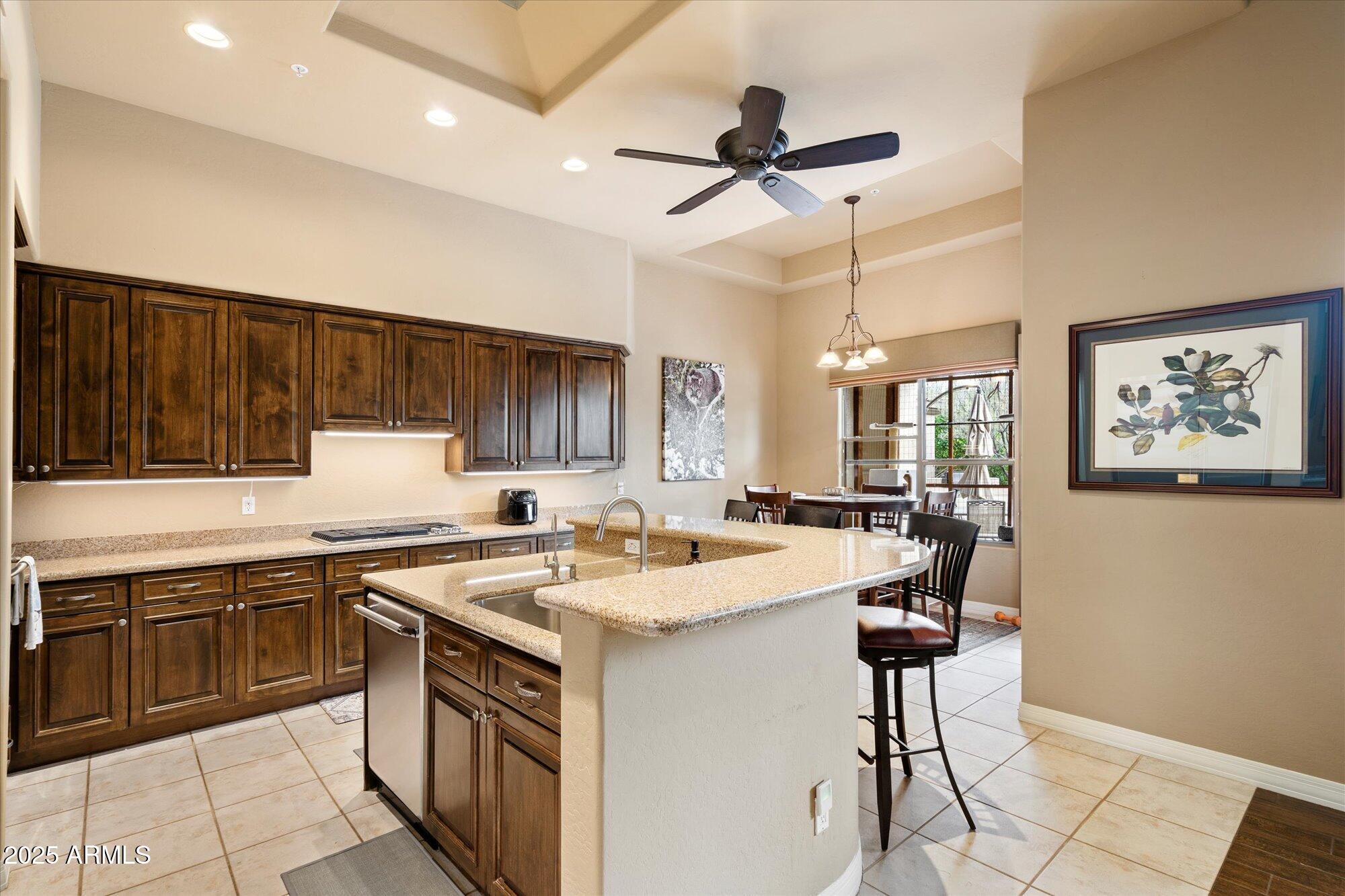6867 East Crimson Sky Trail Scottsdale, AZ 85266 - Photo 21 of 97 a kitchen with a sink a stove a refrigerator and black cabinets with wooden floor