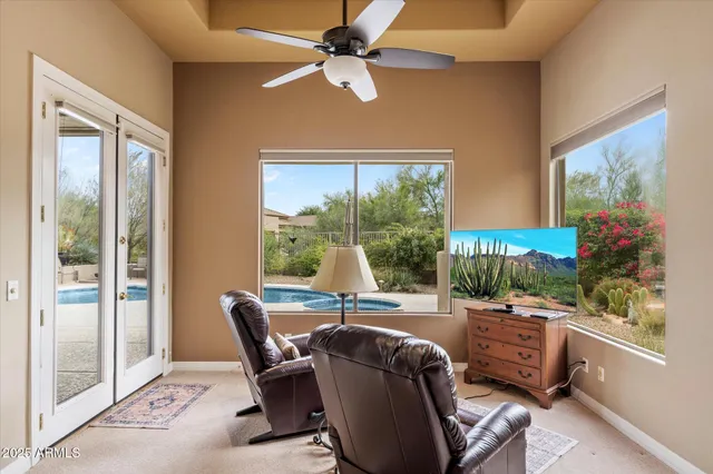 a living room with patio furniture and a floor to ceiling window