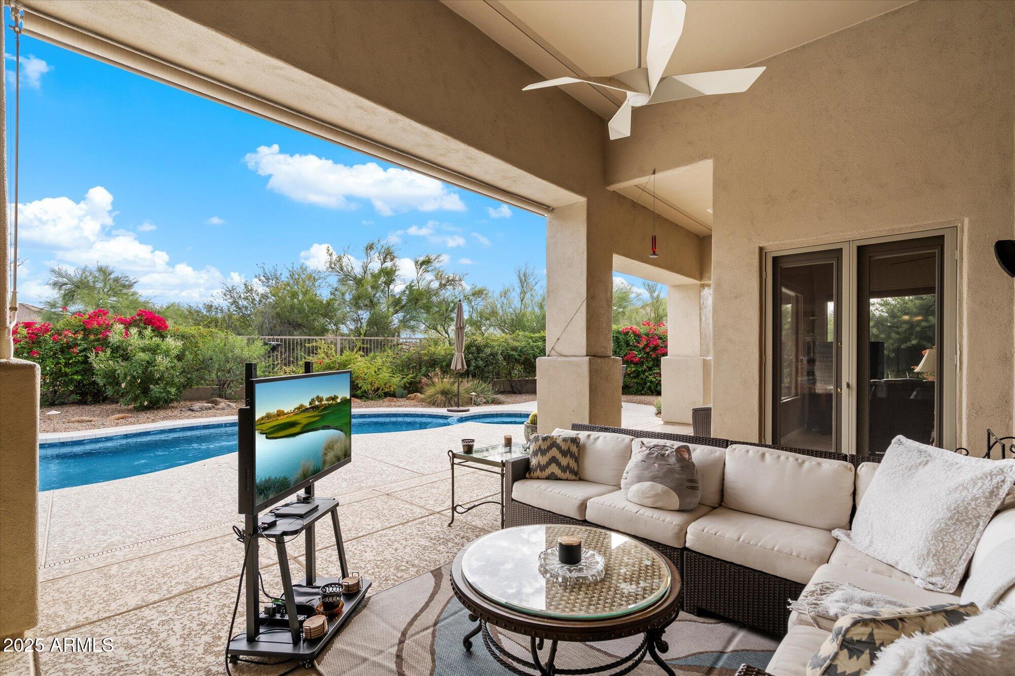 6867 East Crimson Sky Trail Scottsdale, AZ 85266 - Photo 38 of 97 a living room with patio furniture and a floor to ceiling window