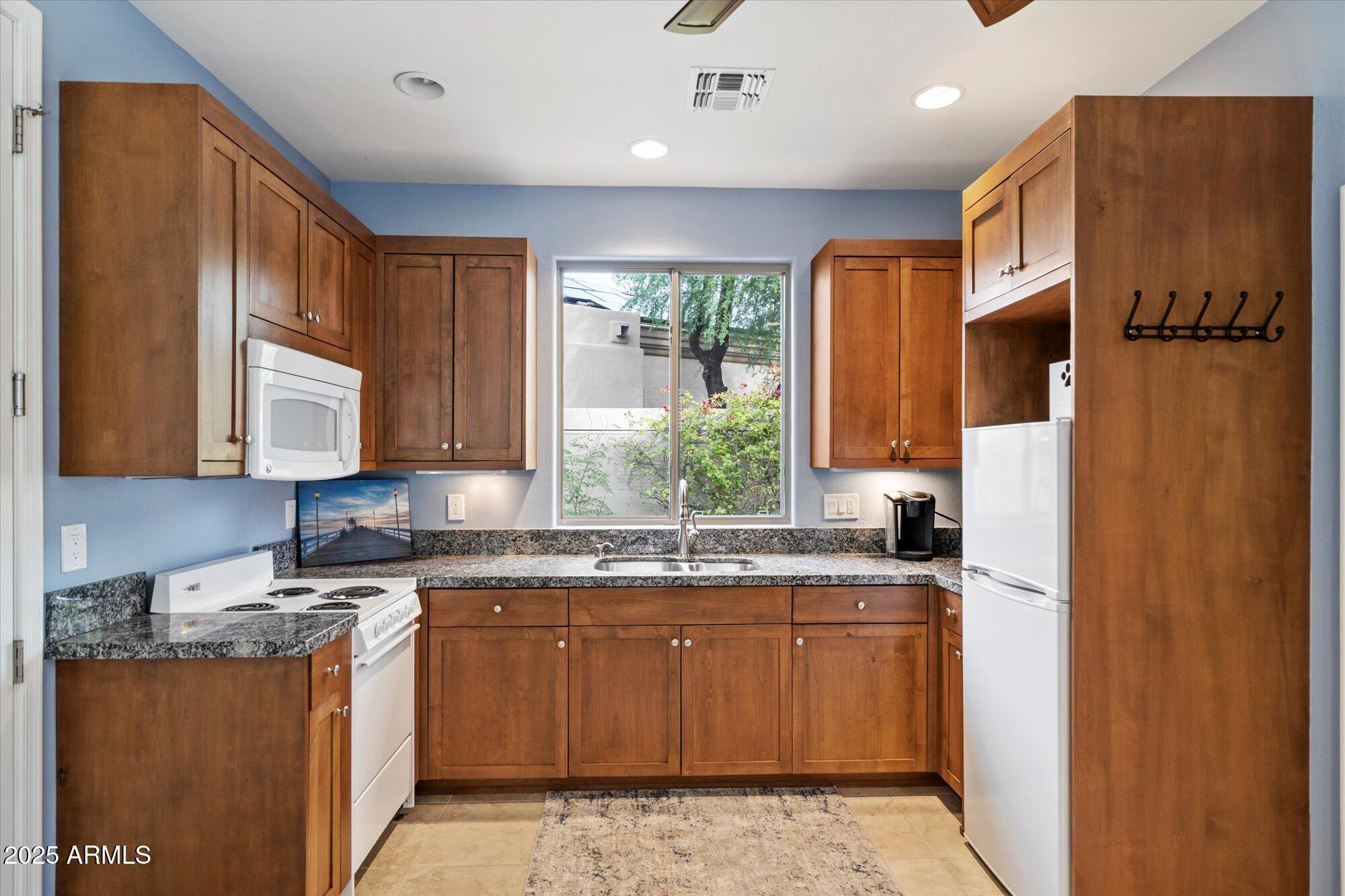 6867 East Crimson Sky Trail Scottsdale, AZ 85266 - Photo 47 of 97 a kitchen with stainless steel appliances granite countertop a sink stove and refrigerator