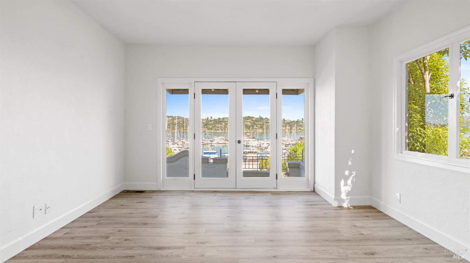 833 Bridgeway, Unit 5 Sausalito, CA 94965 - Photo 13 of 26 an empty room with wooden floor and windows