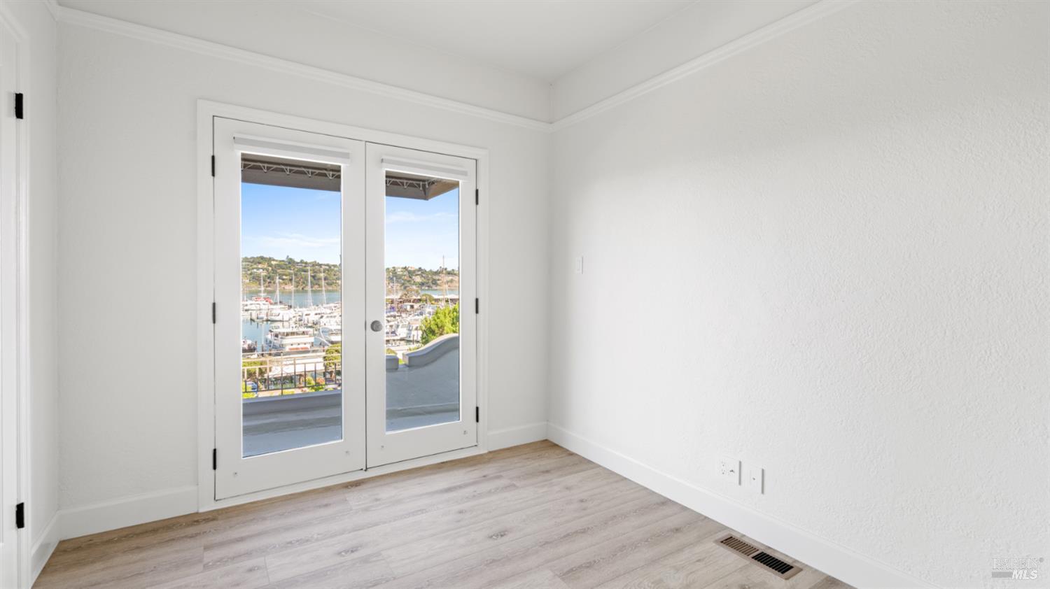 833 Bridgeway, Unit 5 Sausalito, CA 94965 - Photo 8 of 26 an empty room with wooden floor and windows