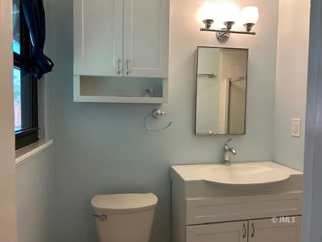 a bathroom with a sink a toilet and mirror