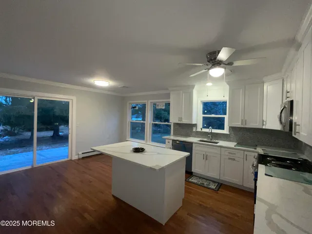 a large kitchen with stainless steel appliances granite countertop a sink a stove and a refrigerator