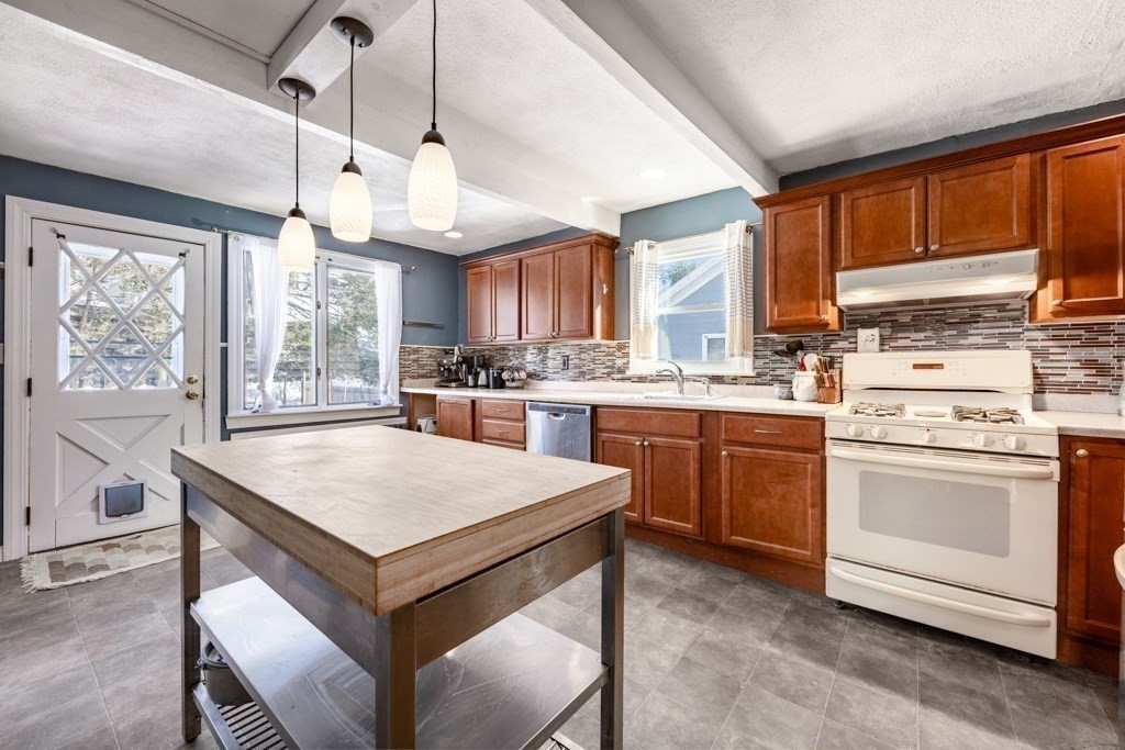 28 Ellsworth Street Medford, MA 02155 - Photo 3 of 23 a kitchen with a stove a sink a center island and windows