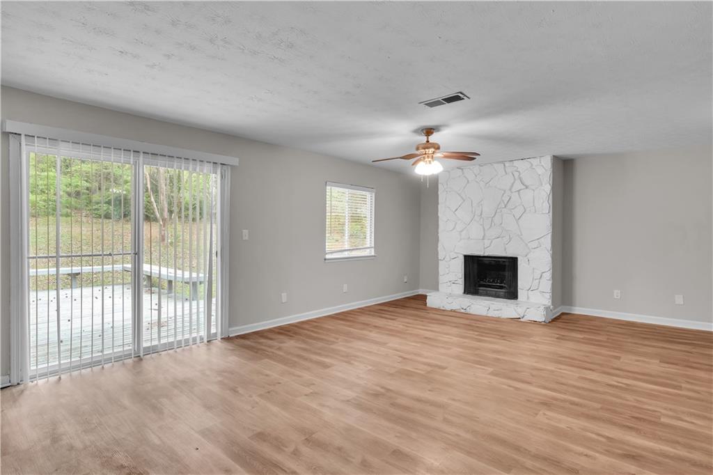 5796 Bobbin Lane Lithonia, GA 30058 - Photo 3 of 17 a view of an empty room with wooden floor fireplace and a window