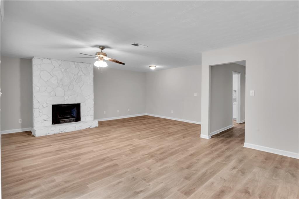 5796 Bobbin Lane Lithonia, GA 30058 - Photo 4 of 17 a view of an empty room with wooden floor and a fireplace