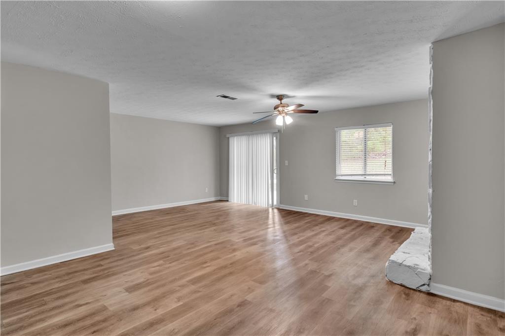 5796 Bobbin Lane Lithonia, GA 30058 - Photo 5 of 17 a view of an empty room with wooden floor and a window