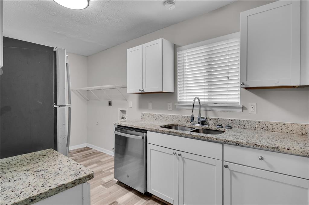5796 Bobbin Lane Lithonia, GA 30058 - Photo 7 of 17 a kitchen with granite countertop cabinets sink and window