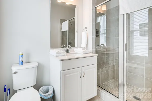a bathroom with a toilet sink vanity and shower