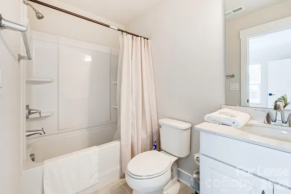 a bathroom with a granite countertop sink toilet a mirror and shower