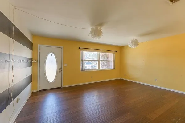a view of a room with wooden floors and windows