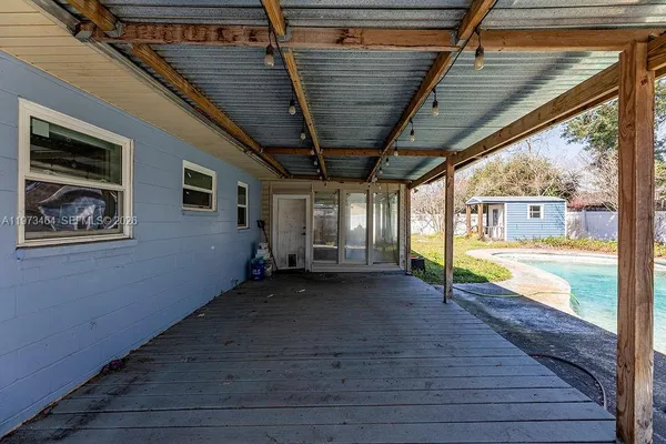 a view of a porch with wooden floor and roof with a barbeque