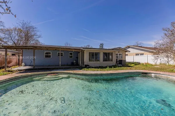 a view of a house with swimming pool and a yard
