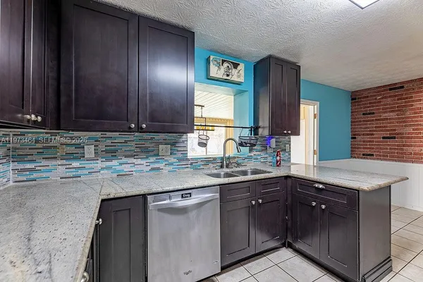 a kitchen with stainless steel appliances granite countertop wooden cabinets a sink and dishwasher