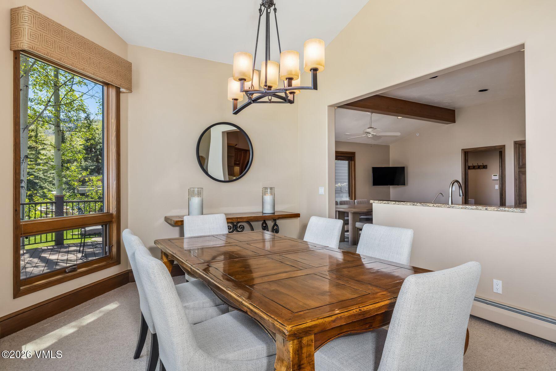 167 Saddle Ridge Edwards, CO 81632 - Photo 10 of 41 a dining room with wooden floor a chandelier a wooden table and chairs